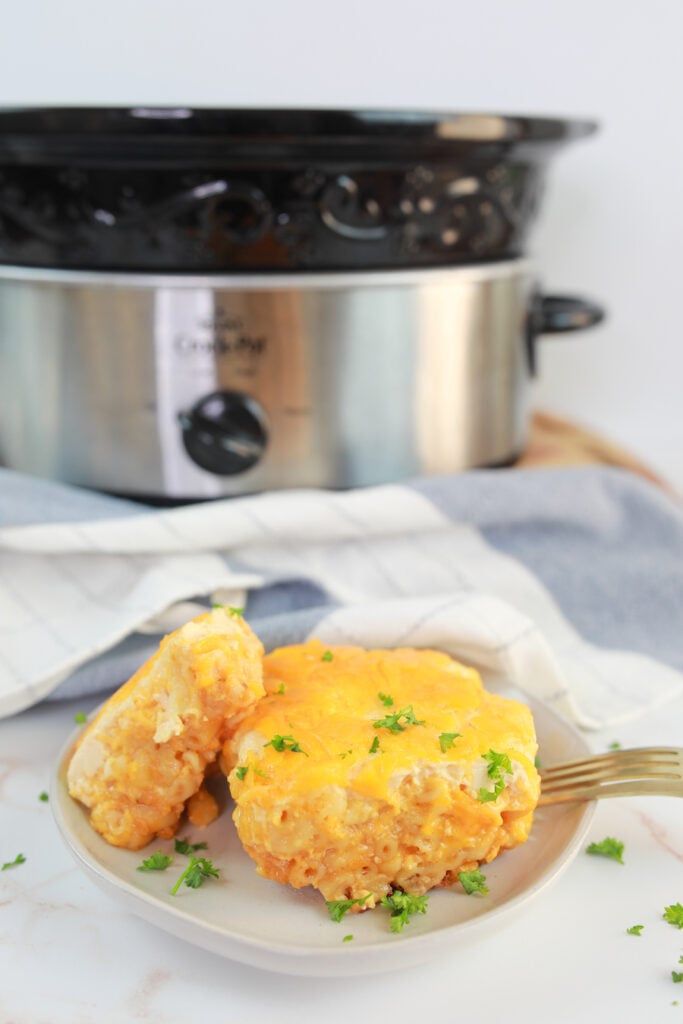 slow cooker macaroni and cheese finished with crockpot in background of photo