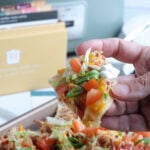 Slow Cooker Chicken Nachos in hand with Recipe box in background
