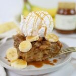 Bananas Foster Bread Pudding wide view finished on plate with bananas and caramel