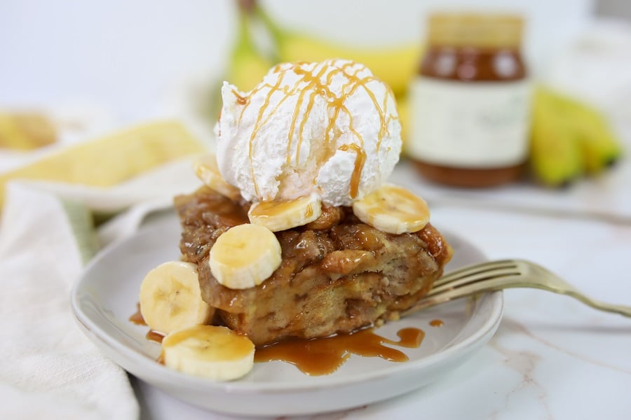 Bananas Foster Bread Pudding wide view finished on plate with bananas and caramel