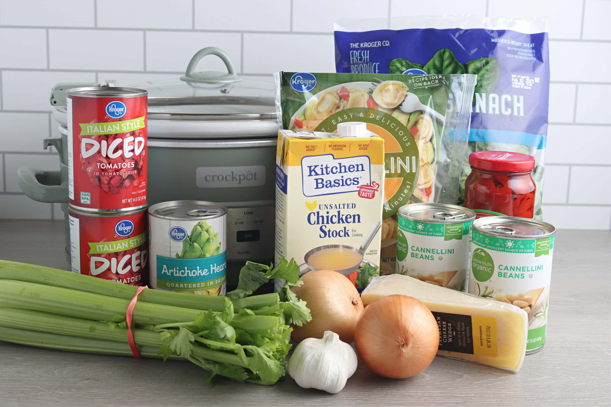 slow cooker tortellini soup ingredients on countertop with slow cooker