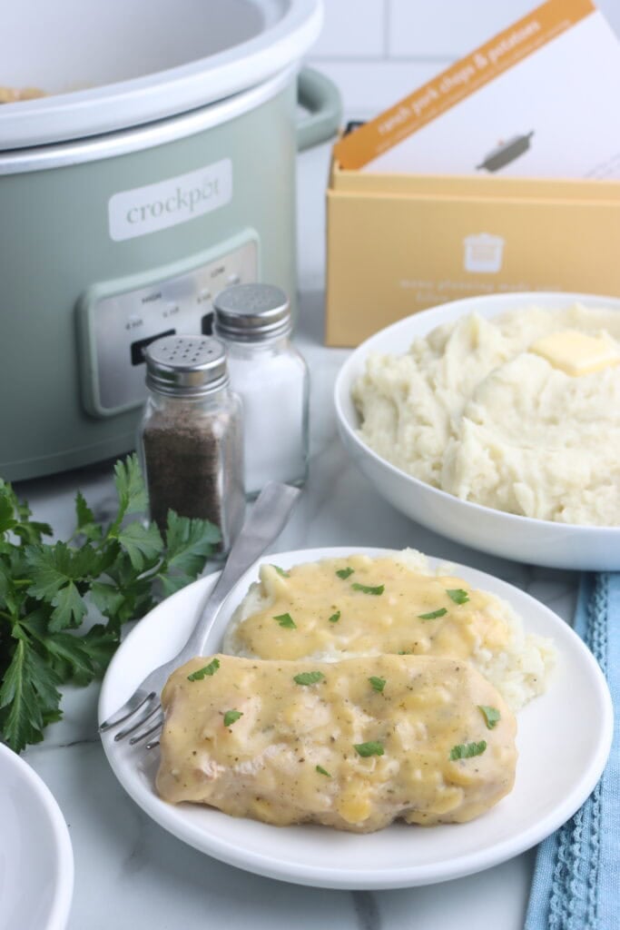 ranch pork chops plated next to mashed potatoes with recipe box behind ranch pork chops plated next to mashed potatoes with recipe box behind