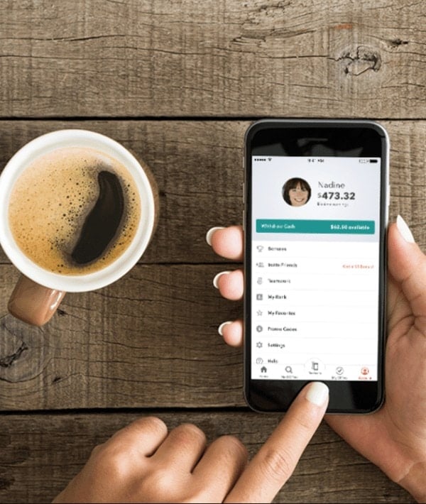 person using ibotta app on phone while drinking coffee 