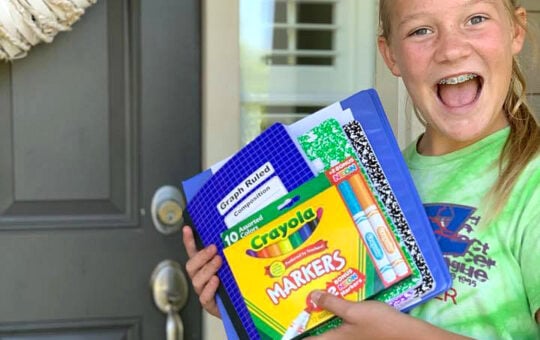 girl holding school supplies