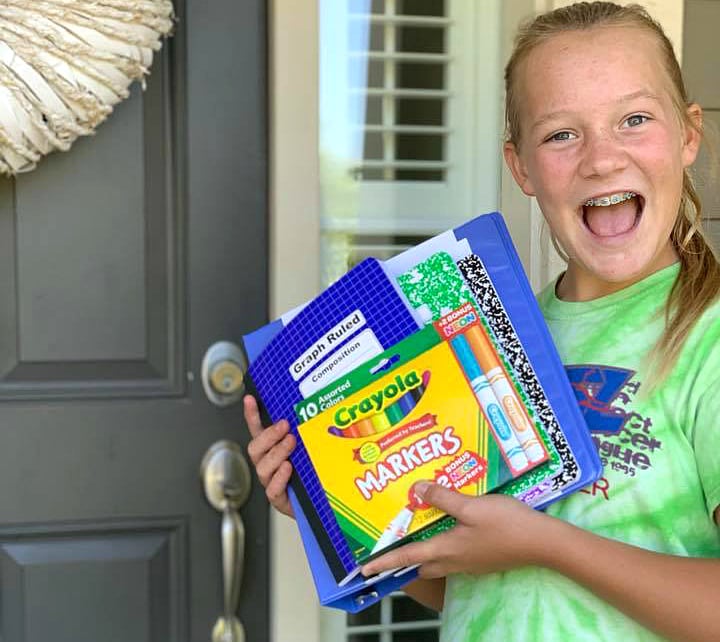girl holding school supplies