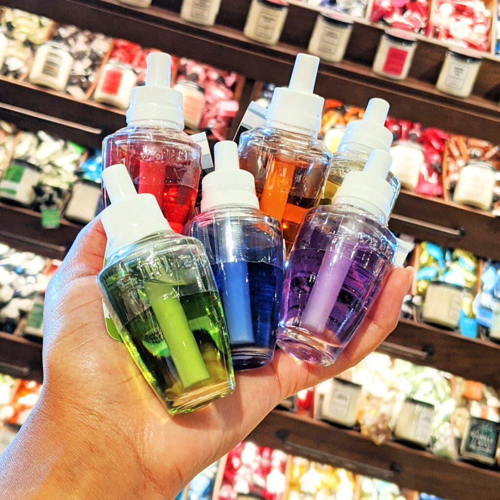 person holding 5 bath body works Wallflower refills