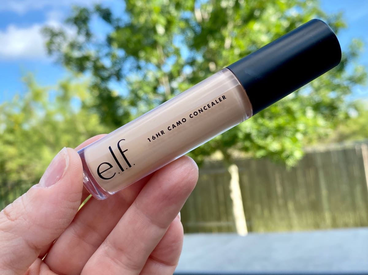 hand holding concealer stick