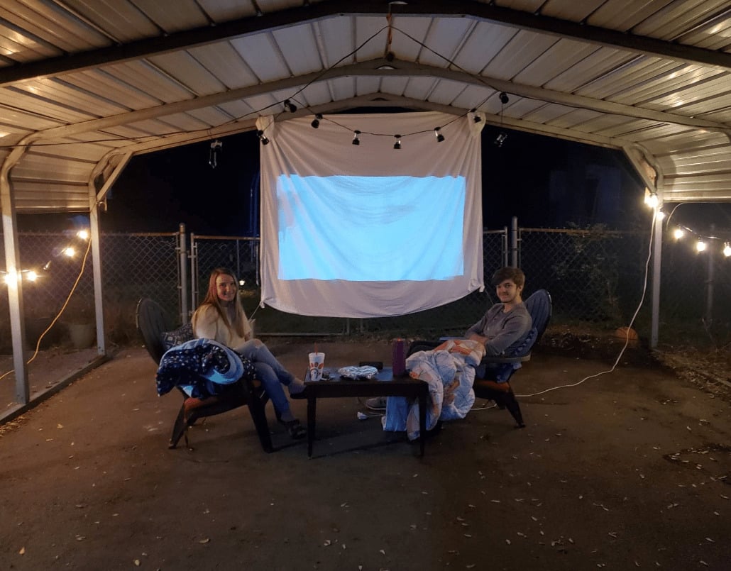 2 kids in front of projector screen outside