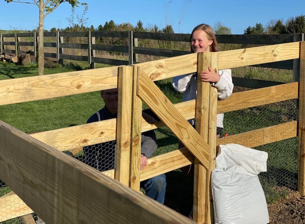 kids inside of fencing smiling