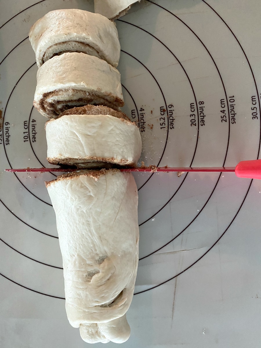 cutting homemade cinnamon rolls