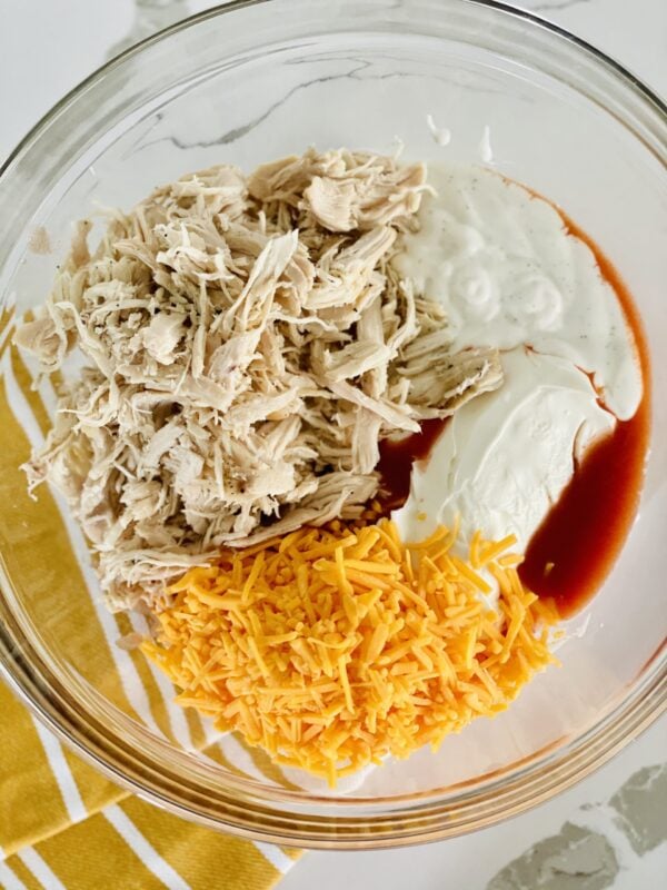 shredded chicken cheese ranch cream cheese and hot sauce in mixing bowl