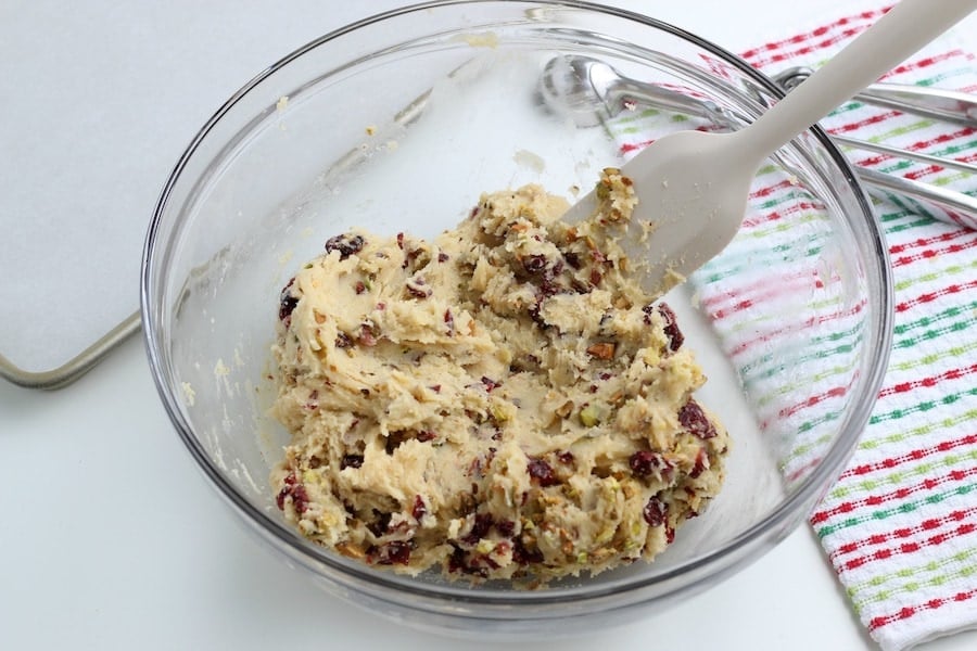 Mixing cookie dough with pistachios and cranberry