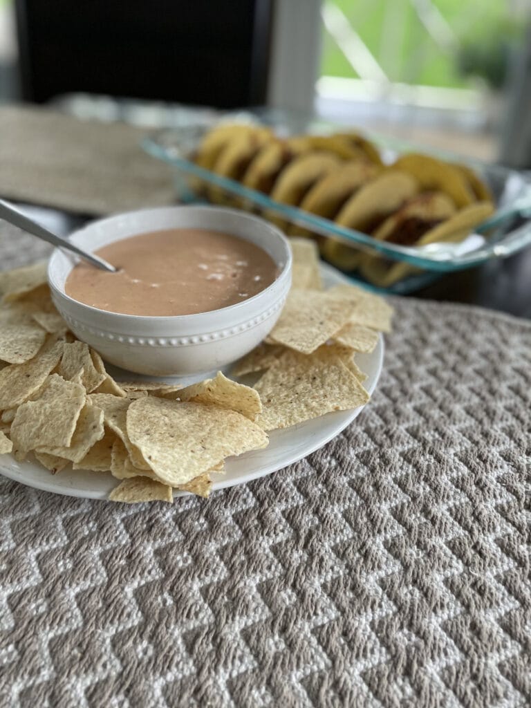 cheese dip with tacos in the background
