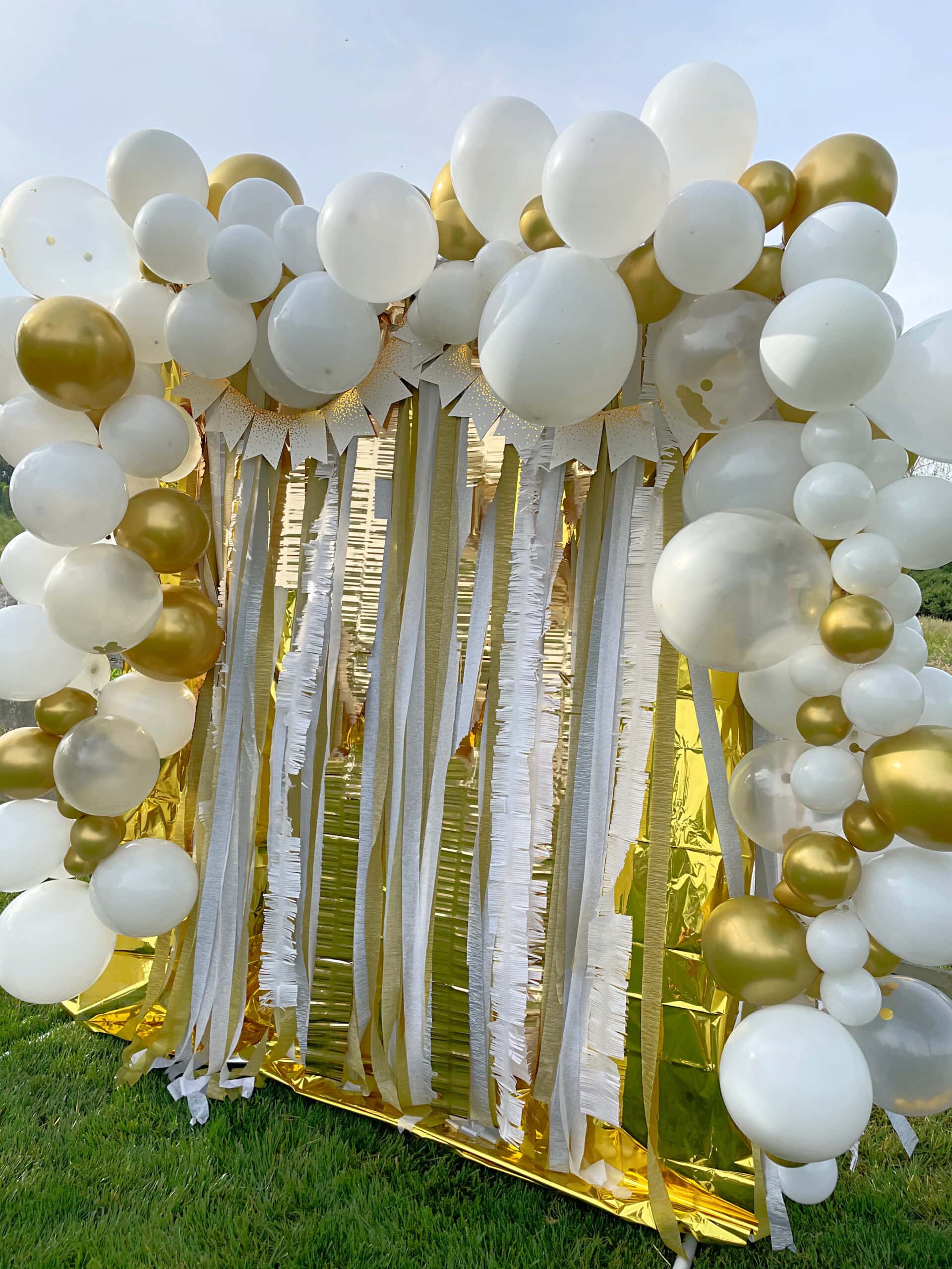 How To Make A Balloon Arch using gold and white balloons with streamers on a balloon frame