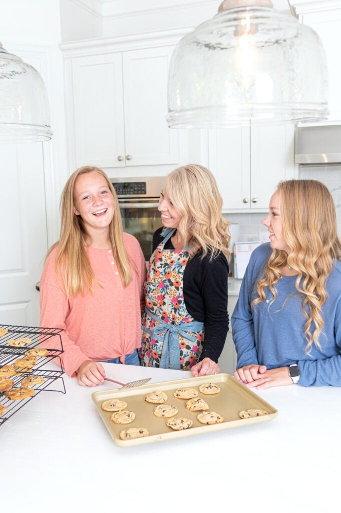 mom and 2 girls baking cookies in kitchen