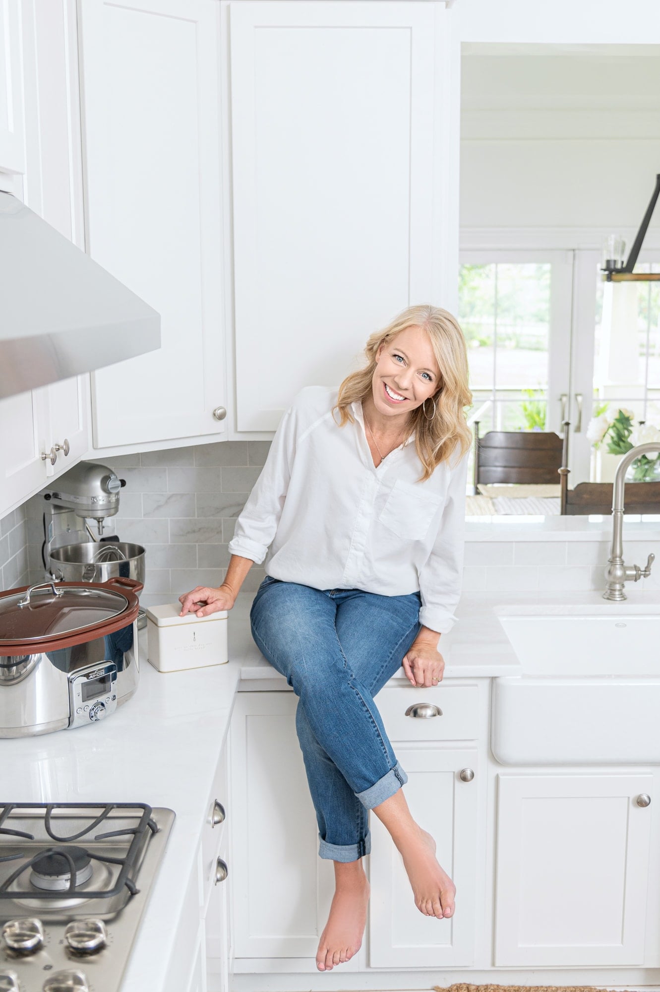 Laurie on counter with cream recipe tin and crock pot in kitchen