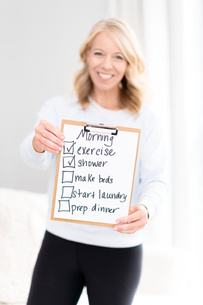 Laurie holding sign with morning checklist of things to do