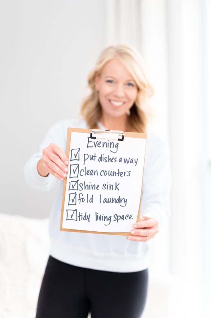Laurie holding sign with evening checklist of things to do
