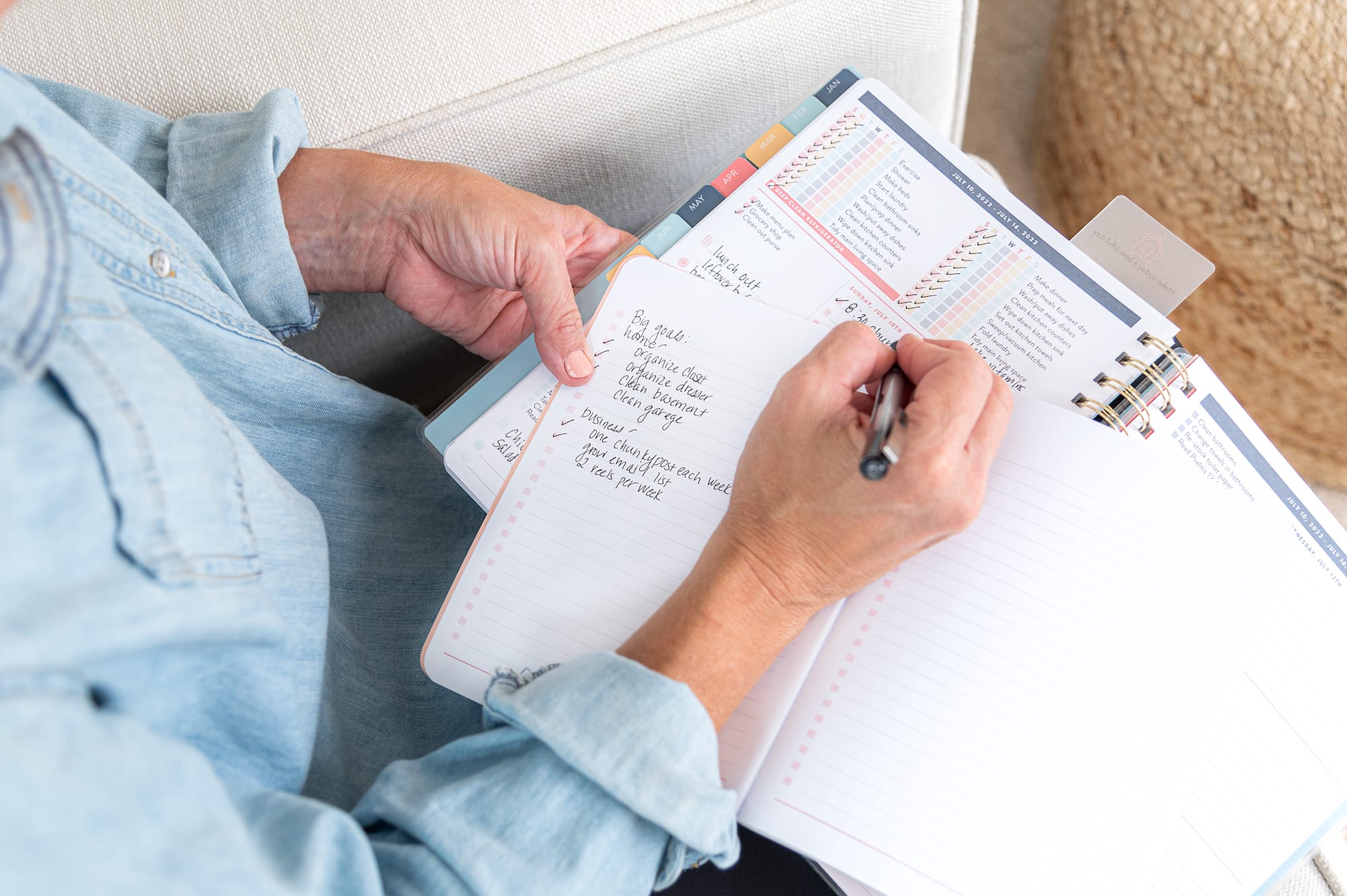 Laurie writing in blank journal with planner
