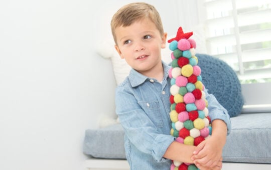 Little boy holding colorful Christmas tree