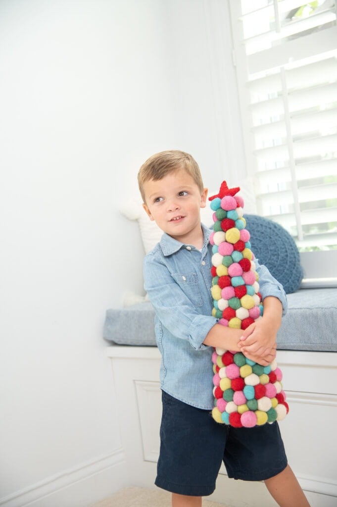 Little boy holding colorful Christmas tree