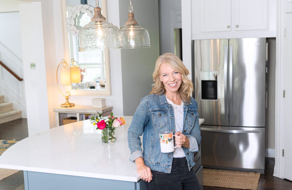 Laurie leaning on kitchen counter with rifle coffee mug