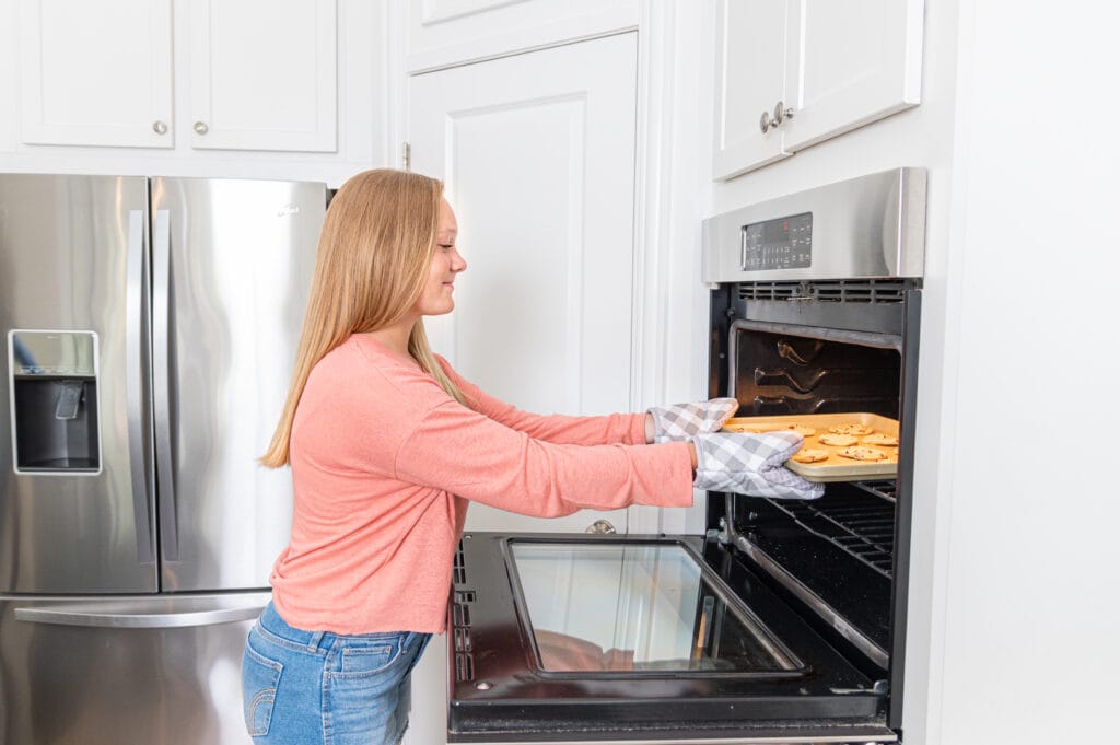 putting cookies into oven