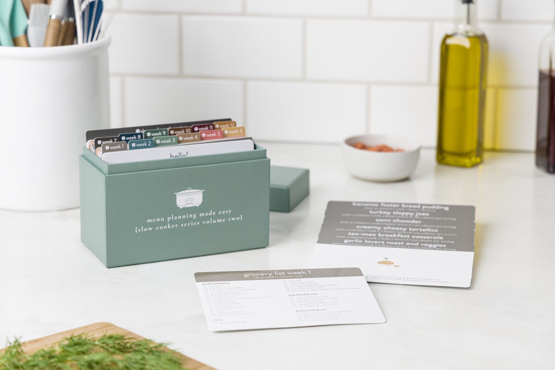 Slow cooker volume 2 box with grocery list and recipes on kitchen counter