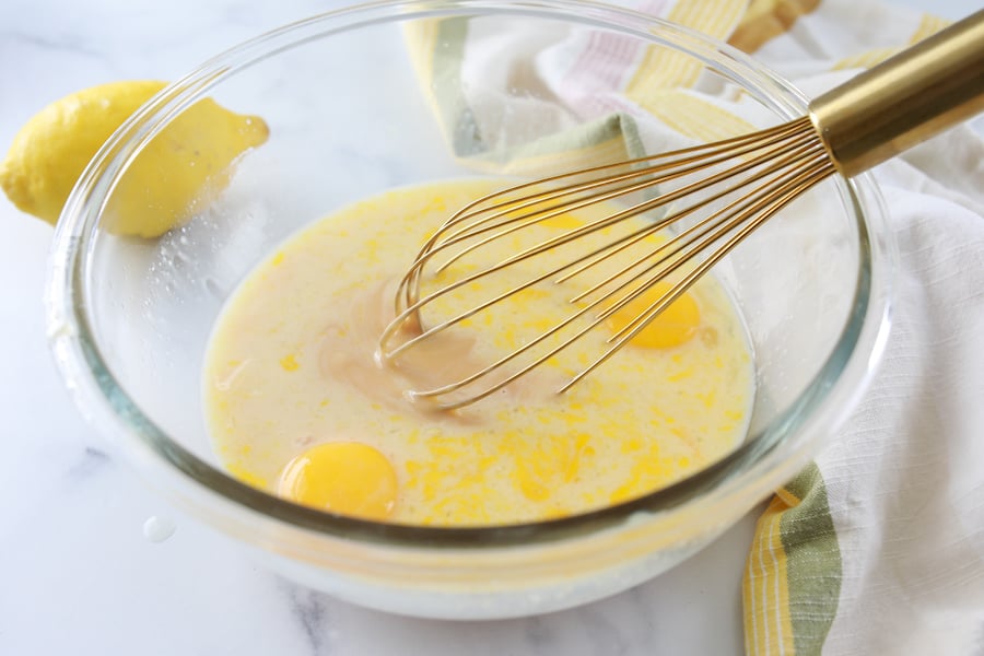 Mixing lemon pie ingredients in bowl with whisk