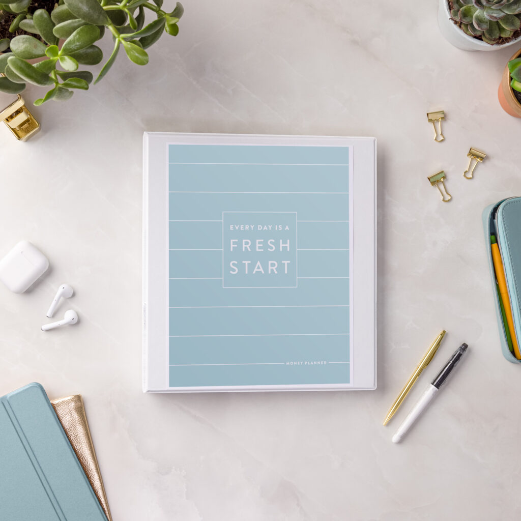 Money Planner PDF in binder on marble background