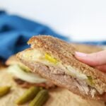 cuban pork sandwich in hand tall view