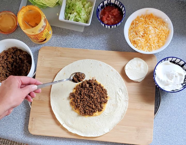 adding meat to tortilla