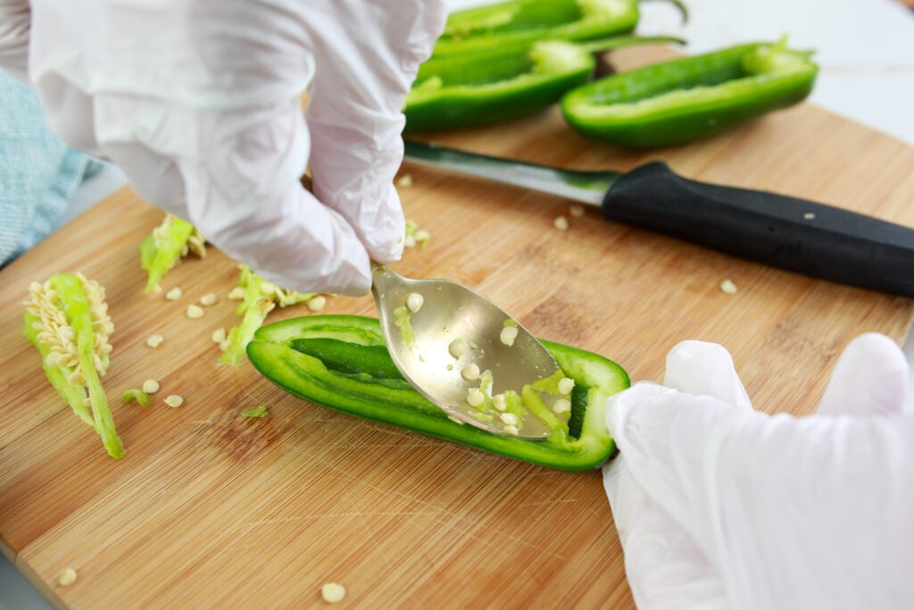 jalapeno poppers seeding with gloves and spoon