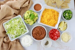 layered tex mex ingredients in white bowls