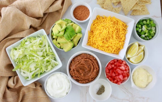 layered tex mex ingredients in white bowls