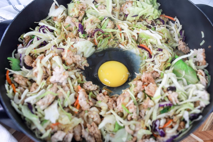 making well in center of ingredients adding an egg in skillet