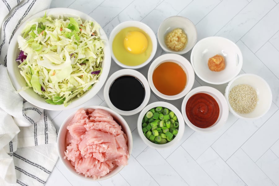 egg roll in a bowl ingredients in white bowls on marble countertop