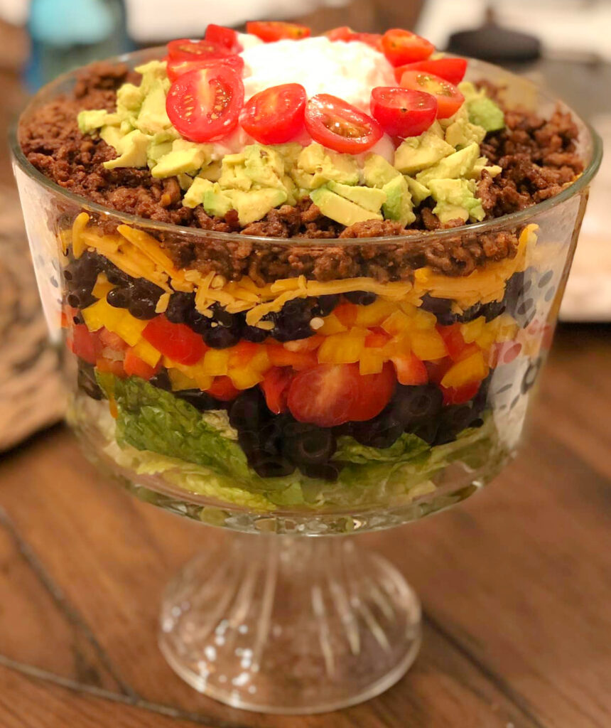 Delicious layered taco salad in a glass dish