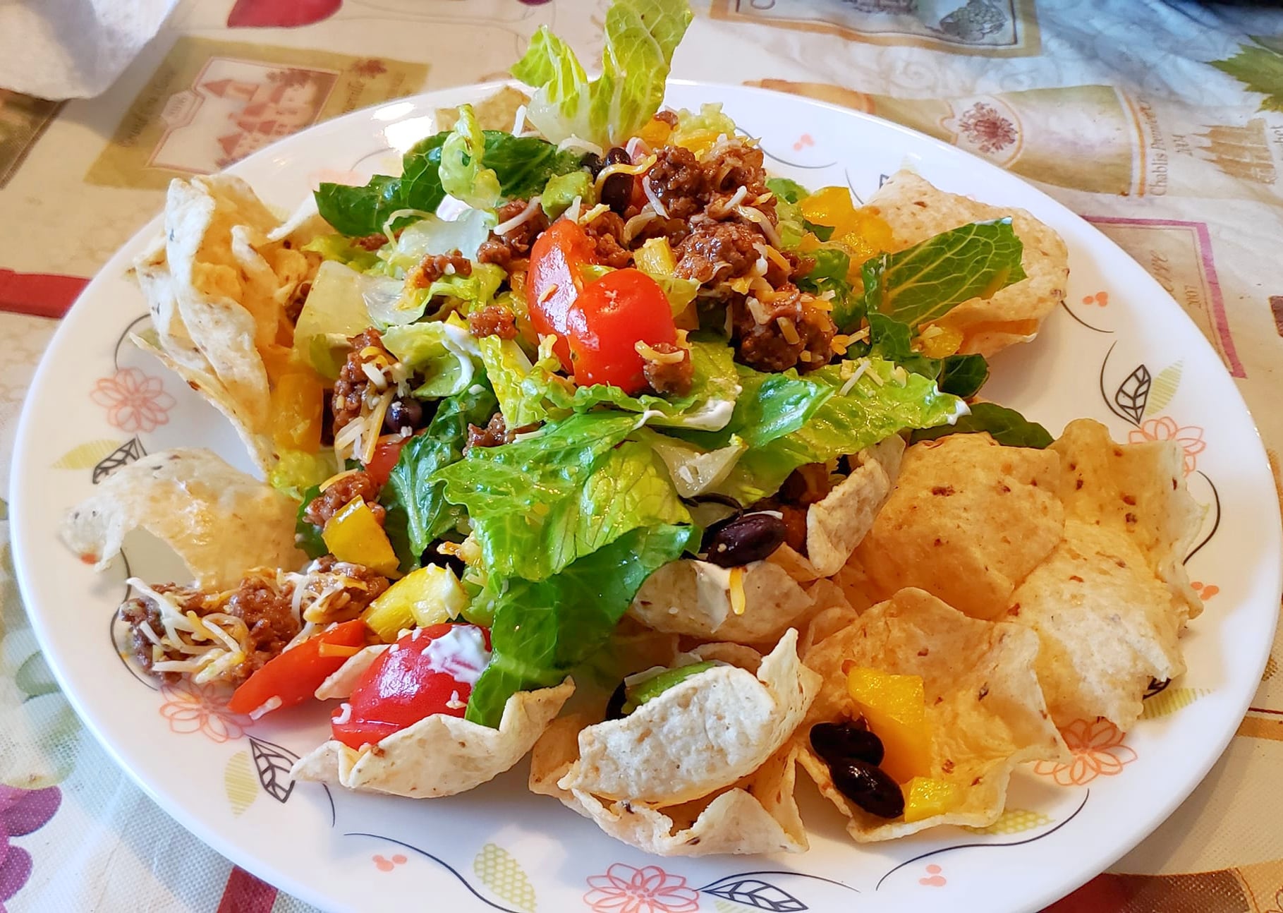 layered taco salad on plate with nachos