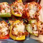 Hot sausage and pepperoni stuffed peppers hot from the oven with melted cheese on top