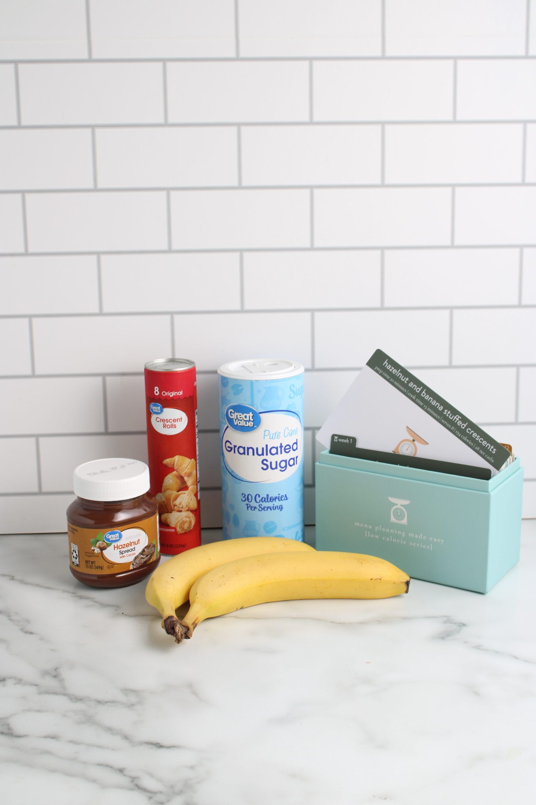 ingredients for Hazelnut and Banana Stuffed Crescents on counter top with recipe box 