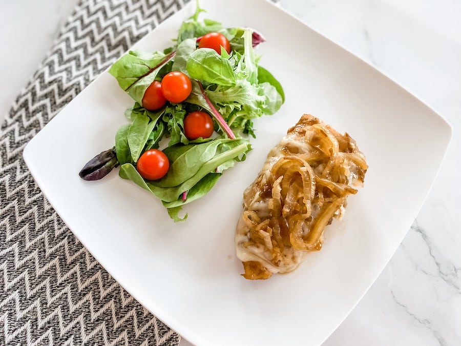 Slow Cooker French Onion Chicken on white plate with side salad 