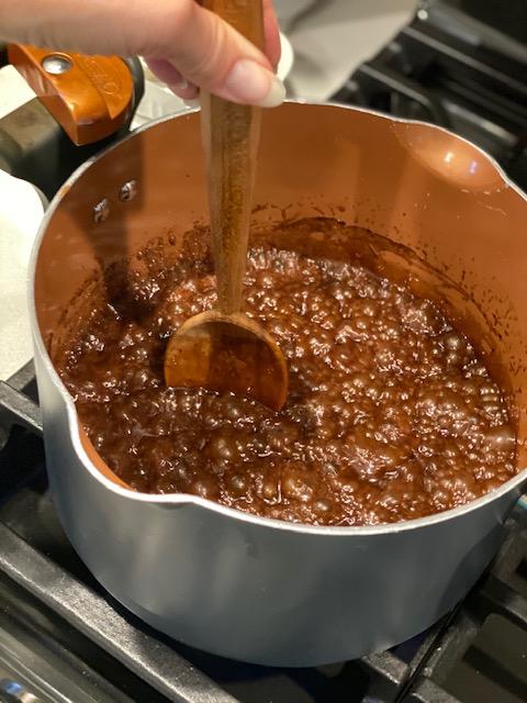 stirring sugar sauce with wooden spoon