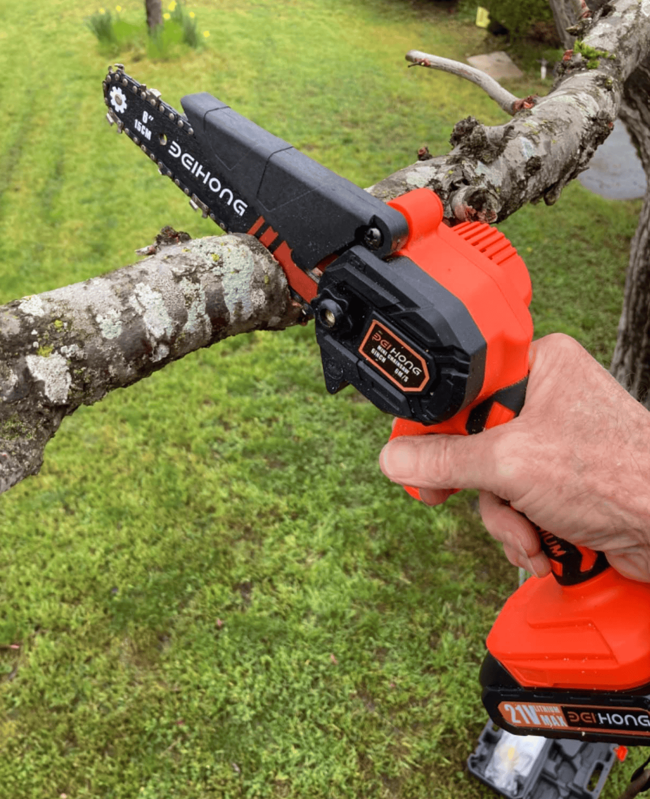 mini chainsaw cutting a branch