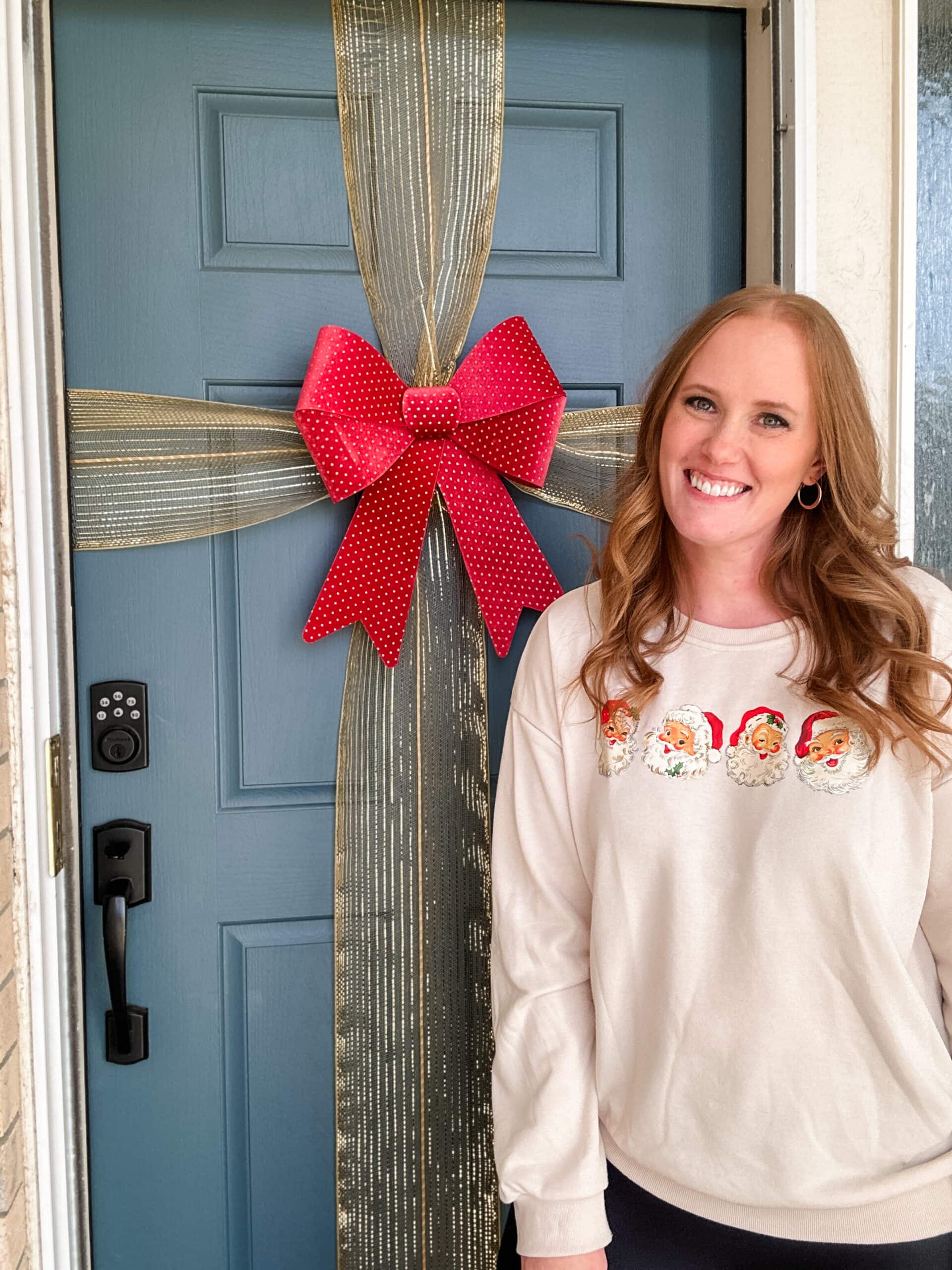 bow on front door with woman standing next to it 