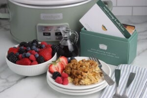 sausage and waffle bake finished on plate with fruit and recipe box