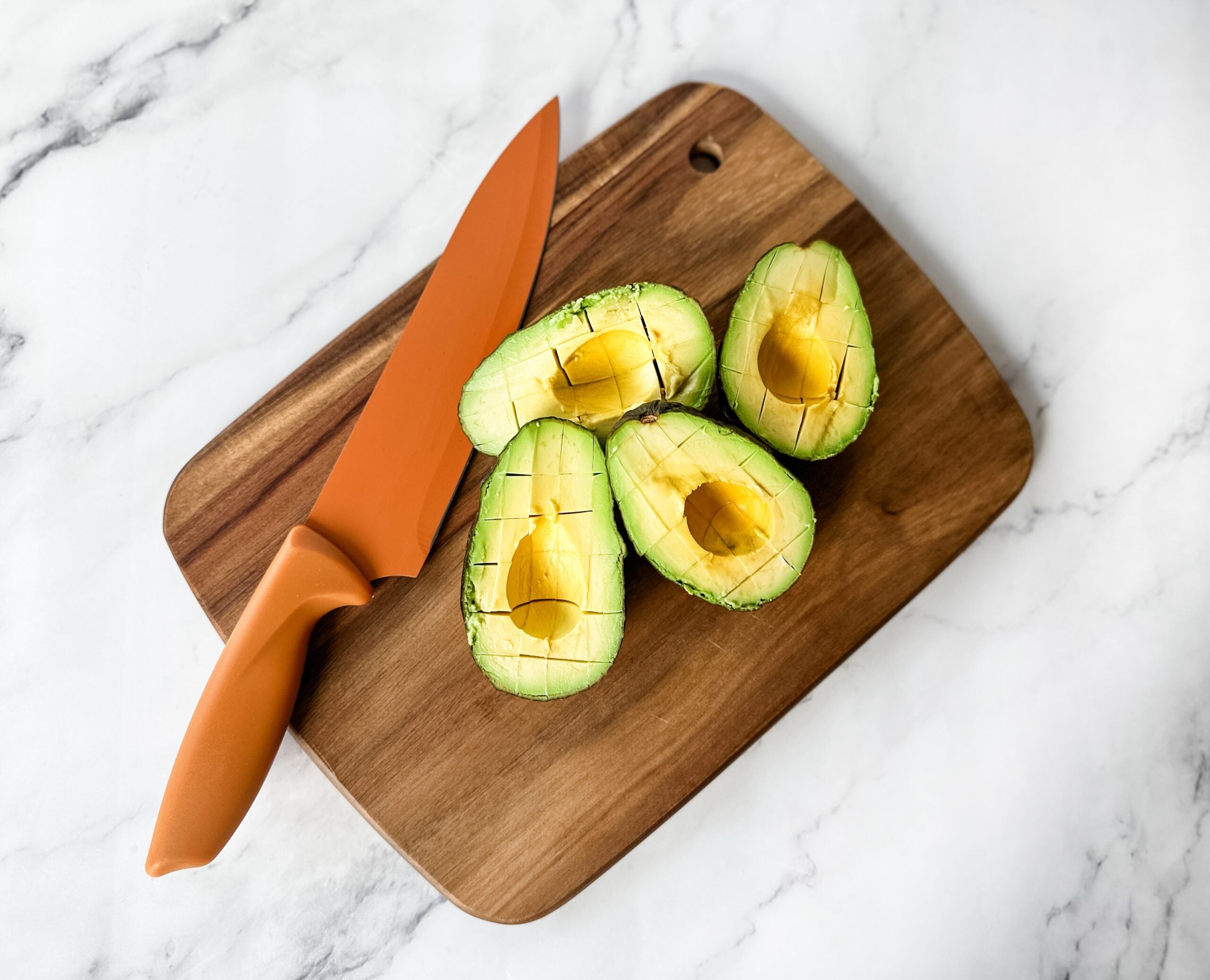 slicing an avocado on cutting board