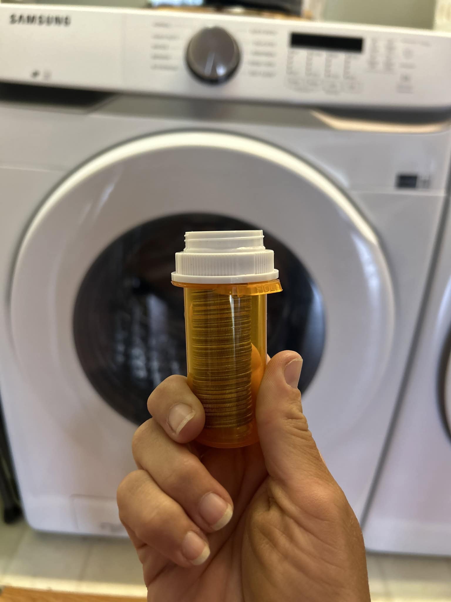 empty pill bottle in front of dryer 