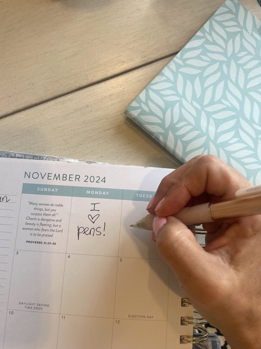 writing in planner with pen