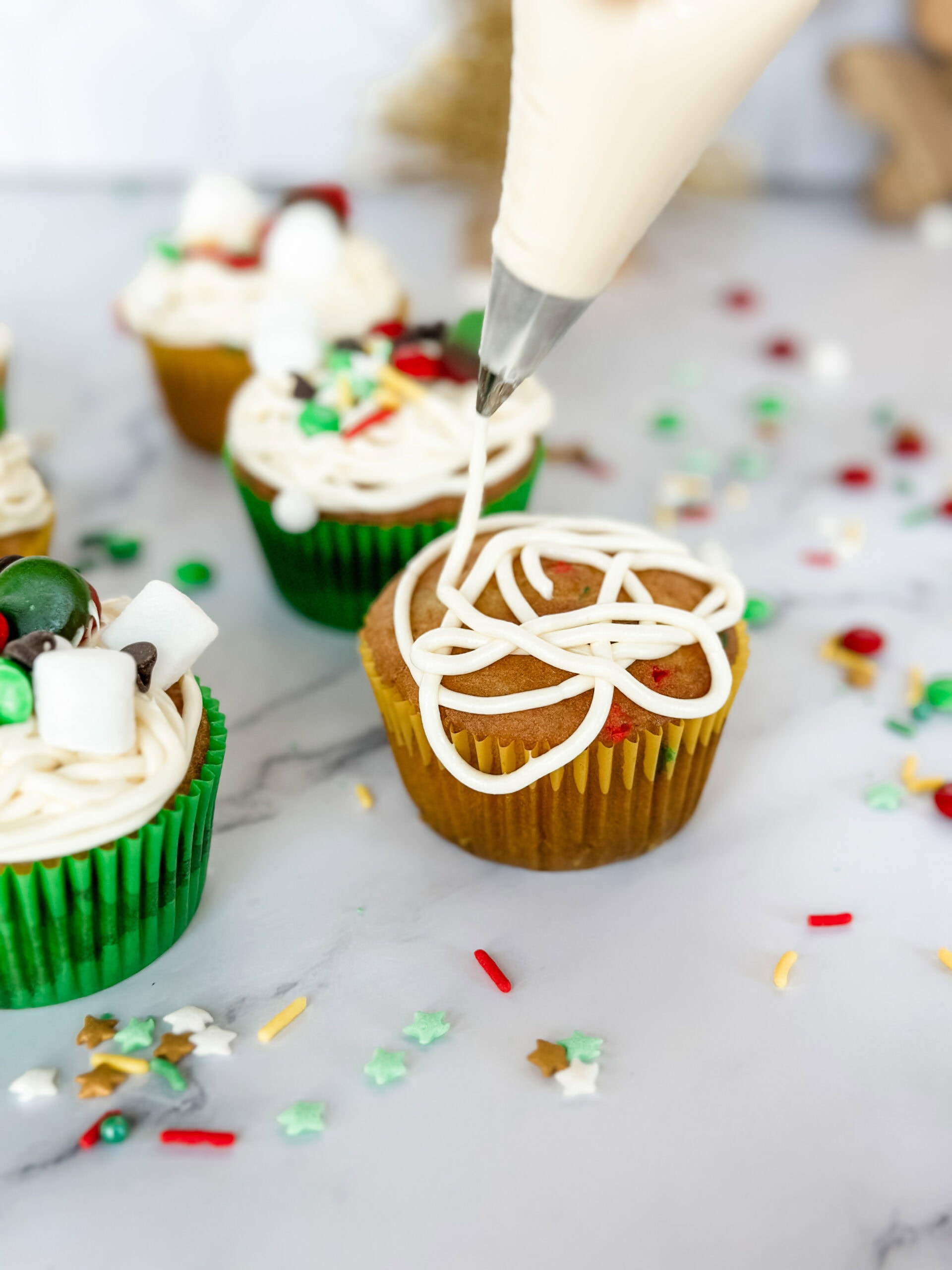adding frosting to cupcakes